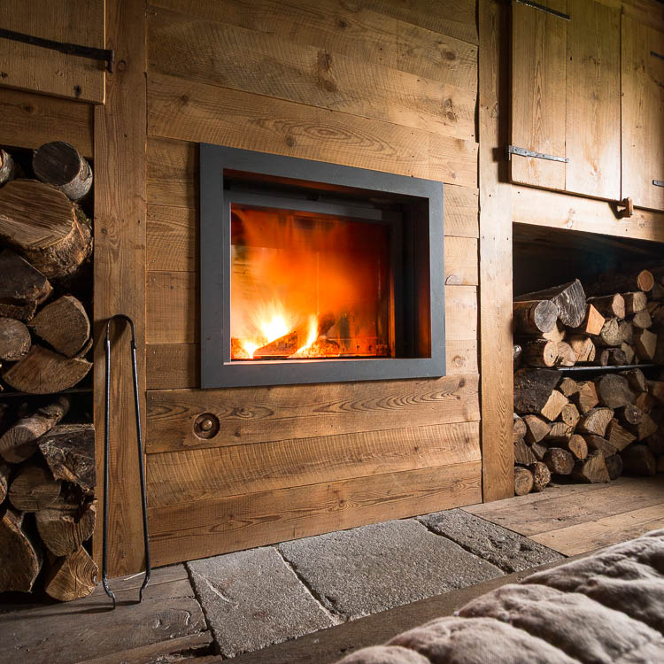 Feu dans l'âtre du buron, bois de chauffage rangé de part et d'autre